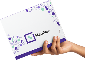 A hand holding a Medpax box